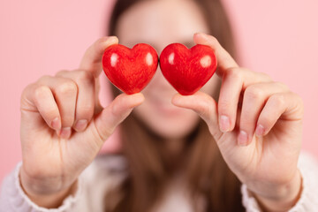Obraz premium closeup hands holding heart on pink background, valentine's day concept