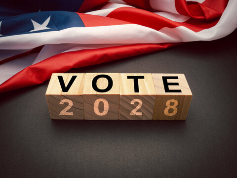 Wooden cubes with the letters VOTE and 2028 on the American flag background