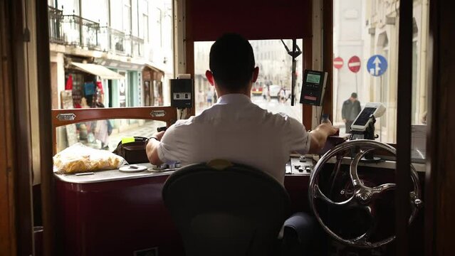 Inside famous old trolley in Lisbon. Tram driver of historic tram train streetcar in Alfama, Lisbon. Tourism landmark, travel destination in Portugal.