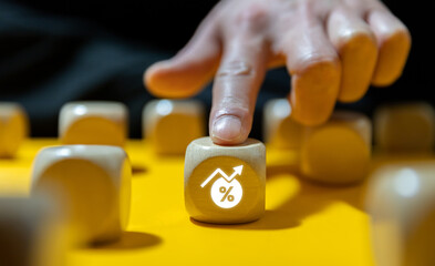 The entrepreneur is holding a block of wood with a percentage and an up arrow. a mortgage rate...