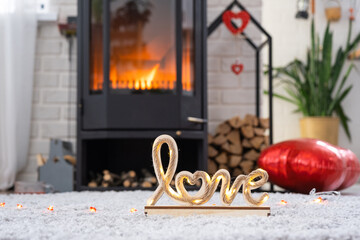 Valentine decor near fireplace stove with fire and firewood. Cozy home hearth in interior with potted plans, valentines day in family love nest. 