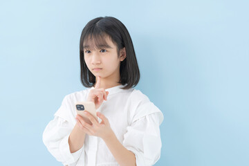 スマートフォン・女の子・ブルーバック