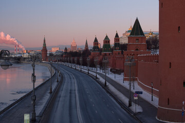 Winter view of the towers of the Moscow Kremlin and the Ministry of Foreign Affairs. Tourist attraction. Car-free Kremlin embankment at dawn. Frosty clear morning.
