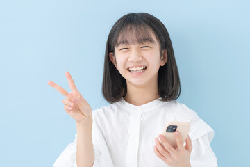 スマートフォン・女の子・ピース・ブルーバック