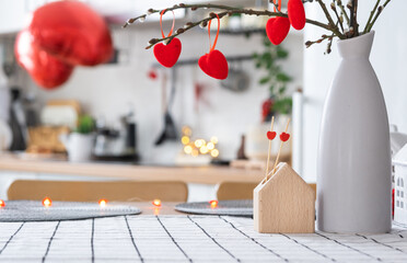 Valentine decor on table of white kitchen in cozy home. Copy space. Gift for valentines day, family love nest. A vase with a bouquet of hearts in a modern interior.