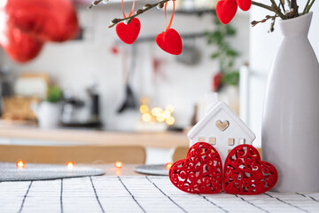 Valentine decor on table of white kitchen in cozy home. Copy space. Gift for valentines day, family love nest. A vase with a bouquet of hearts in a modern interior.