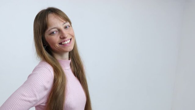 Portrait of young brunette woman on white background smiles and laughs to the camera