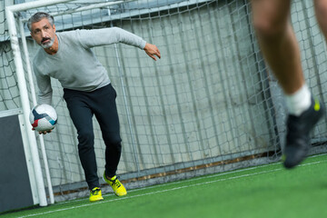player hits the ball on the artificial turf