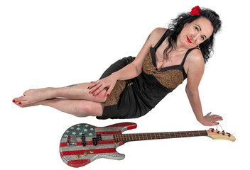 Beautiful brunette woman in a black dress with a bass guitar