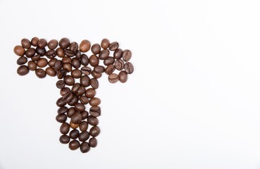 T is a capital letter of the English alphabet made up of natural roasted coffee beans that lie on a white background. Plenty of space to put text or pictures, top view and studio photography.
