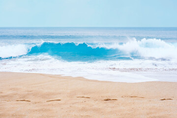 A sea wave with foam and sandy shore, summer background.
