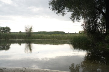 Fototapeta premium Cumulo nimbus clouds at sunset reflected in a lake