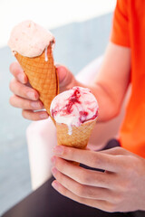 Hand holding gelato cone ice cream in two hands