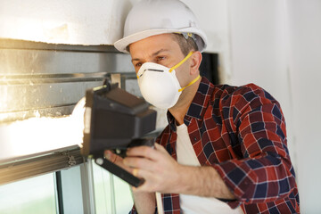 Fototapeta na wymiar male worker wearing protective mask working on window