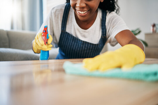 Hand, cleaning and latex gloves with a black woman using a cloth in a home for hygiene as a housekeeper. Furniture, bacteria and chemical with a female cleaner working in housekeeping in an apartment
