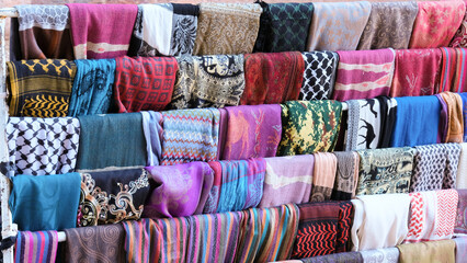 A variety of traditional colourful, patterned headscarf souvenirs for sale by Bedouin vendors in...