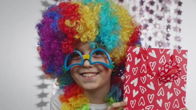 Boy of 10 years old dressed in clown's wig and eyeglasses. 