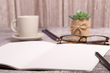 notebook with blank pages, glasses and coffee mug