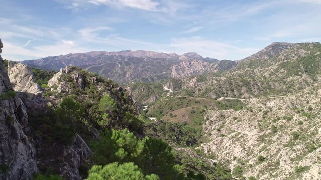 Low level aerial view revealing high mountain peaks and Mediterranean forest. Grenade. Spain.