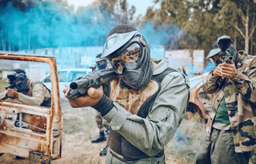 Fototapeta premium Paintball, teamwork and shooting with people in field for sports, target and fitness games. War, smoke and community with man gamer playing in camouflage for military, army and competition training