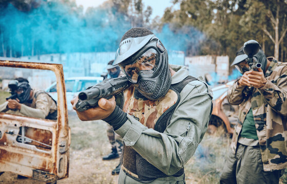 Paintball, teamwork and shooting with people in field for sports, target and fitness games. War, smoke and community with man gamer playing in camouflage for military, army and competition training