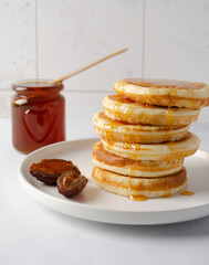 Natural organic homemade date syrup with morning pancakes for healthy breakfast on the background
