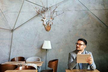 Portrait of young business man working on digital tablet