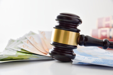 Gavel on table full of money and books isolated background