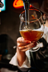 woman bartender hand at beer tap pouring a draught beer in glass serving in a restaurant or pub