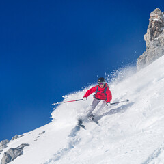 Naklejka na ściany i meble Junge Skifahrerin fährt spektakulär im felsigen Gelände an der Nordkette oberhalb Innsbruck