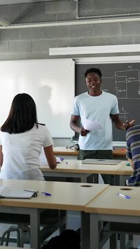 African American male college student presenting a project reading essay to classmates and teacher at High School classroom - Diversity in Higher Education
