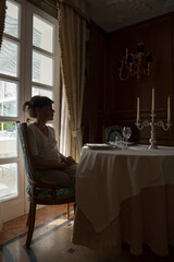 Woman Sitting at a Table with Candlestick in a Restaurant in Italy.