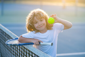 Child playing tennis on outdoor court. Tennis is my favorite play. Portrait of a pretty sporty...