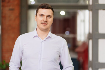 Fototapeta premium a man in a white shirt in the office. the portrait of an entrepreneur.