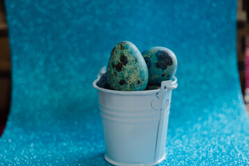 Eggs in a metal bucket on a blue background