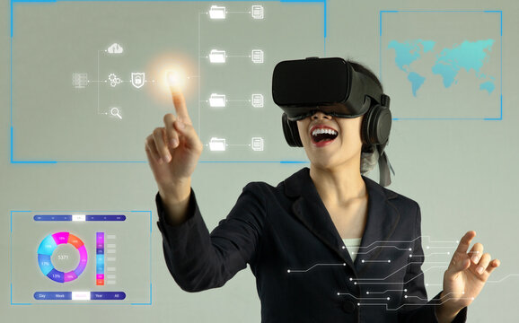 Metaverse technology concept. Asian businesswoman wearing vr headset watching, touching on virtual reality world icon, connecting and control online network and strategy.