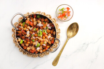 High in protine boiled black chana or chickpea salad. Chopped tomatoes, onion, chilies, and coriander mixed with boiled peanuts or bengal gram. Weight loss meal. Served with Lemon. Copy space.