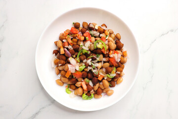 High in protine boiled black chana or chickpea salad. Chopped tomatoes, onion, chilies, and coriander mixed with boiled peanuts or bengal gram. Weight loss meal. Served with Lemon. Copy space.