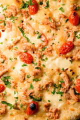 Close-up top view on pizza topping with cherry tomatoes and chicken garnished by green