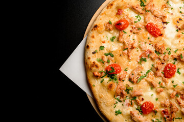 Great top view on fragment of pizza with cherry tomatoes and chicken garnished by green