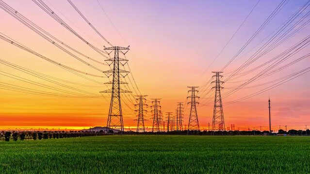 High voltage electric towers at sunrise. Transmission power line. Electricity pylons and sky clouds background.