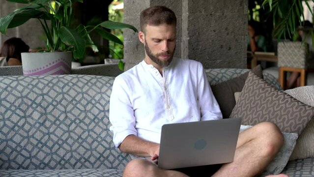 Skilled male with modern laptop technology browsing web information using 4g internet while working remotely, Caucasian man downloading media file on netbook while watching online video
