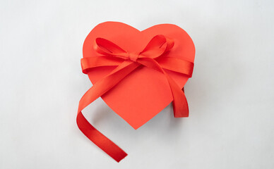 Heart gift box with red ribbon tie. Love shape design element
