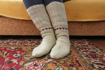 Warm knitted socks are worn on the feet.