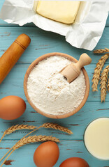 Ingredients for baking or cooking, egg flour, rolling pin butter, milk on a blue wooden background Cookie pie or cake recipe.