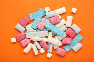 Different chewing gums on orange background.