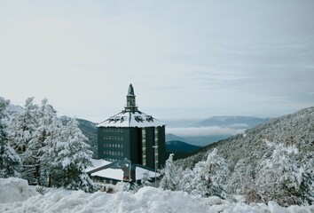 snowy landscape with mountains and a building of the sierra de navacerrada in madrid
