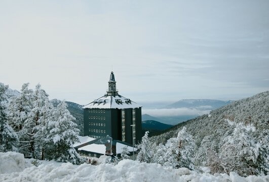 snowy landscape with mountains and a building of the sierra de navacerrada in madrid