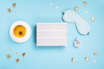 Sleeping Masks, Turmeric Golden Milk Latte and Alarm Clock on Blue Background. World Sleep Day Concept.