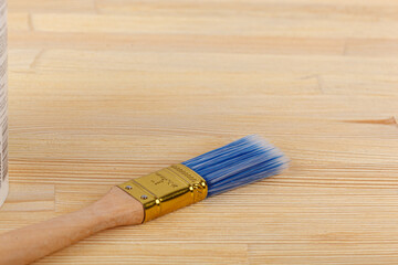 white paint with a brush on a wooden background with texture